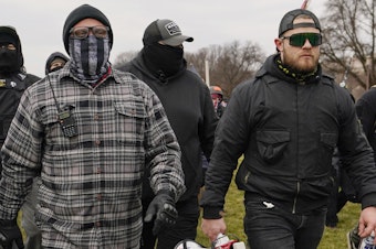 caption: Proud Boys member Ethan Nordean, right with megaphone, walk toward the U.S. Capitol in Washington, Jan. 6, 2021.