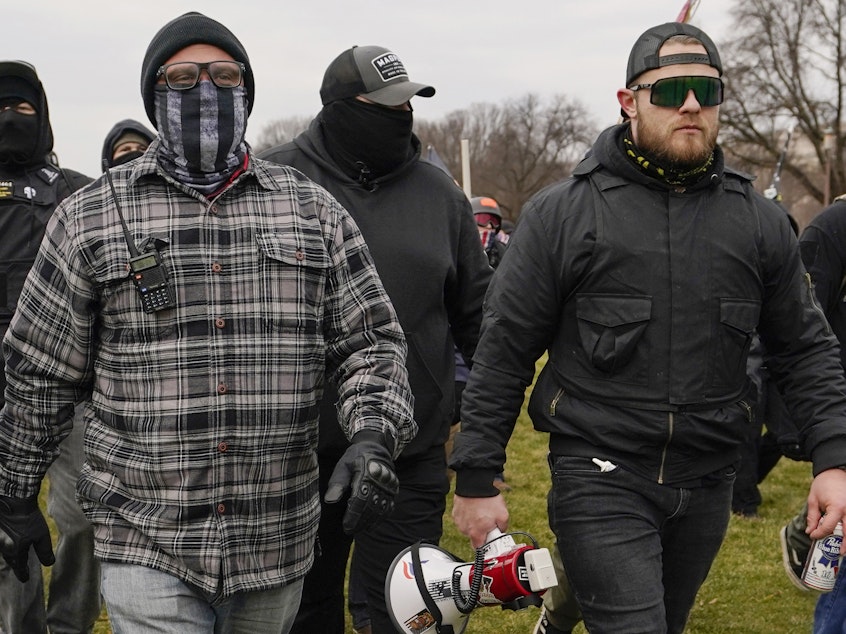 caption: Proud Boys member Ethan Nordean, right with megaphone, walk toward the U.S. Capitol in Washington, Jan. 6, 2021.