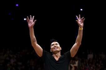 caption: Jerome Aparis, also known as Jeromeskee, with the Massive Monkees raises his hands to the crowd after competing in the Red Bull Lords of the Floor breakdancing competition on Saturday, April 6, 2024, at WAMU Theater in Seattle. 