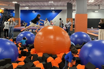 caption: Children jump at Sky Zone in Mountlake Terrace's new neighborhood near the light rail station