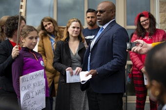 caption: Parents confront Seattle Public Schools Superintendent Brent Jones before a meeting about the proposed closure of 20 elementary schools on Tuesday, May 28, 2024, at Roosevelt High School in Seattle. 