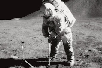 caption: Astronaut James B. Irwin, lunar module pilot, uses a scoop in making a trench in the lunar soil during Apollo 15 extravehicular activity (EVA). Irwin had a heart attack while orbiting the moon, which made NASA realize that they needed a better health monitoring system.