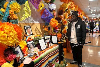 caption: Arron Murphy-Paine visiting a Dia de los Muertos altar for his son Amarr at El Centro de la Raza celebration on November 2, 2024.