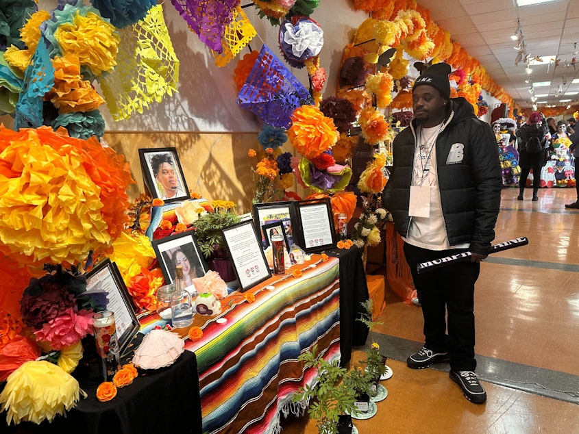 caption: Arron Murphy-Paine visiting a Dia de los Muertos altar for his son Amarr at El Centro de la Raza celebration on November 2, 2024.