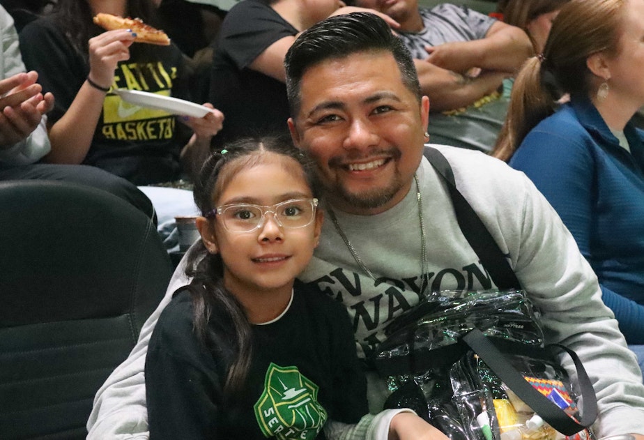 caption: Jason Gregarious and his daughter Mara are at Climate Pledge Arena for Caitlin Clark's first game in Seattle in May 2024. Mara wears a Seattle Storm shirt, but her favorite player is still Clark.