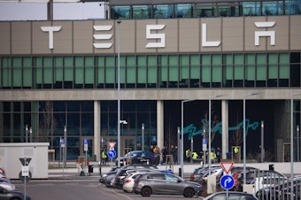 caption: The Tesla Inc. Gigafactory in Grünheide, Germany, on Tuesday. The company halted production at its factory outside of Berlin and sent workers home after suspected arson at a nearby high-voltage pylon caused power failures throughout the region.