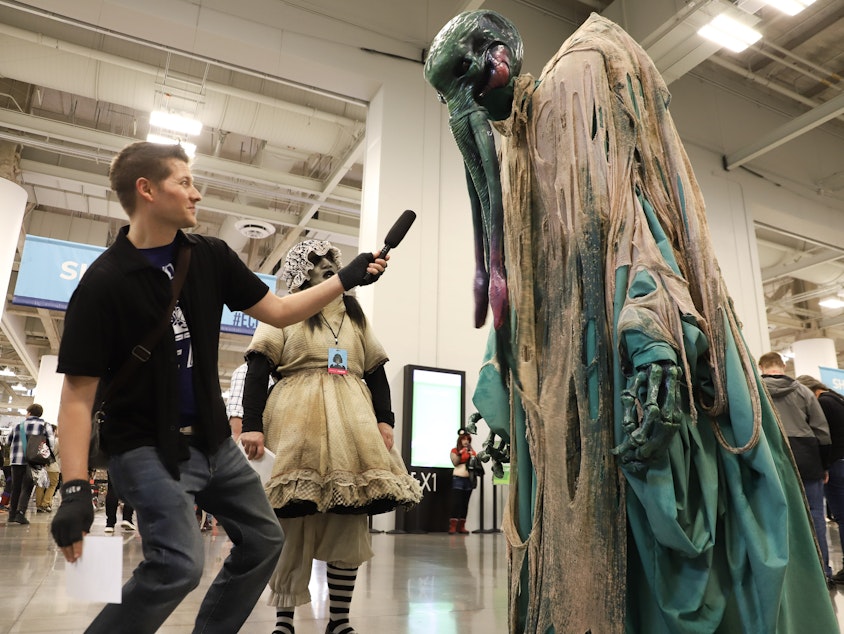 caption: KUOW's Dyer Oxley interviews Cthulu, a cosmic entity created by writer H. P. Lovecraft, at Emerald City Comic Con on Feb. 29, 2024.