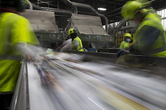 caption: Employees remove items that cannot be recycled from a conveyer belt on Friday, Oct. 26, 2018, at Cascade Recycling Center in Woodinville, Washington. 