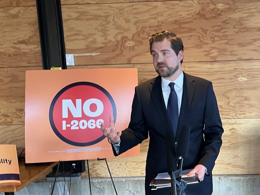 caption: Kai Smith, a lawyer for the climate groups, solar energy industry representatives, and governments suing to overturn Initiative 2066, speaks to reporters at Metier Brewing in Seattle on Dec. 11, 2024.