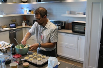 caption: Primed host Joshua McNichols bakes muffins in Amazon's smart home laboratory test kitchen.