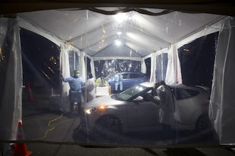 caption: Healthcare workers administer the first doses of the Moderna Covid-19 vaccine for healthcare workers during a drive-thru vaccination clinic on Thursday, January 7, 2021, in Renton. 