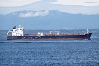 caption: The oil tanker West Virginia motors through Puget Sound, with the Olympic Mountains in the background, on Aug. 19, 2024.