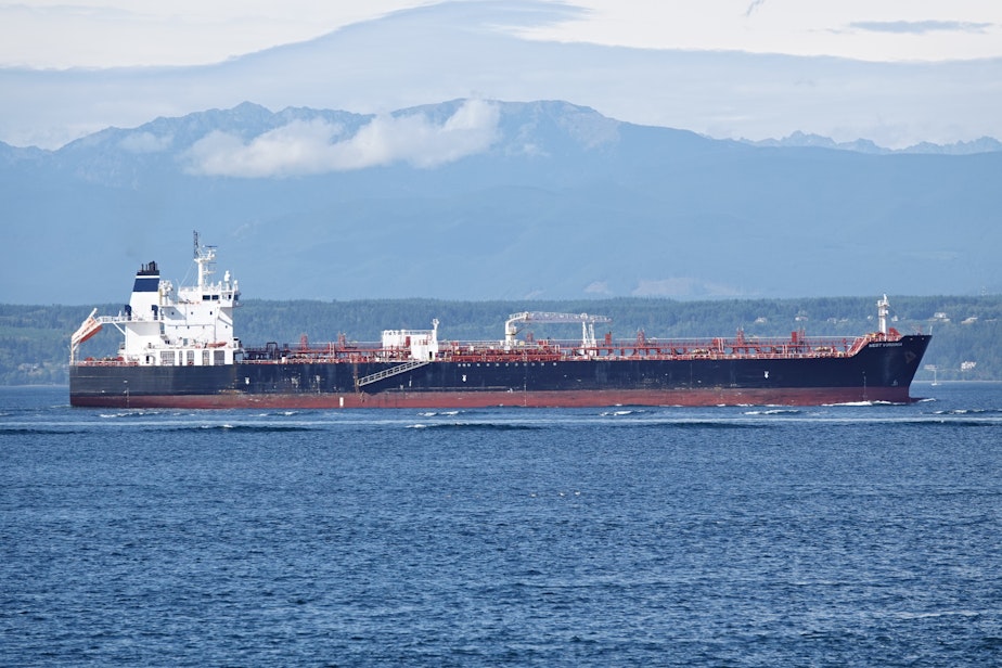 caption: The oil tanker West Virginia motors through Puget Sound, with the Olympic Mountains in the background, on Aug. 19, 2024.