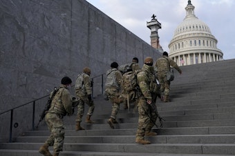 caption: National Guard members take a staircase toward the U.S. Capitol building before a rehearsal for President-elect Joe Biden's Inauguration in Washington on Jan. 18, 2021. Experts in constitutional law and the military say the Insurrection Act gives presidents tremendous power with few restraints.