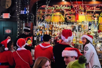 caption: Santas party at Merchants Cafe & Saloon during SantaCon on Dec. 7, 2024.