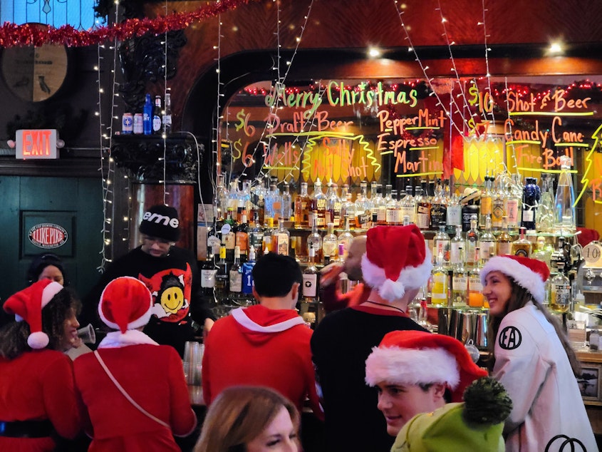 caption: Santas party at Merchants Cafe & Saloon during SantaCon on Dec. 7, 2024.