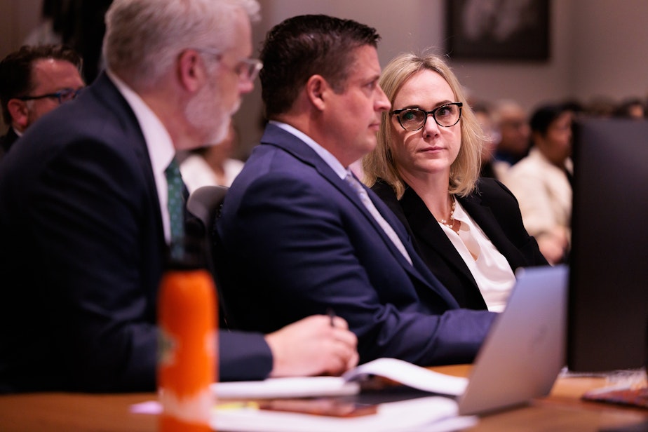 caption: Attorney Tim Leary, from left, Auburn Police Officer Jeffrey Nelson, attorney Emma Scanlan listen to closing arguments at Maleng Regional Justice Center in Kent, Wash. Thursday, June 20, 2024. 