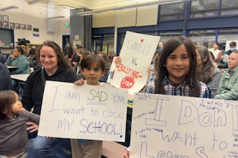 caption: Rachelle Carrillo poses for a photo with her three children. She was among dozens of parents to attend a community closure meeting Tuesday at Sanislo Elementary in West Seattle.