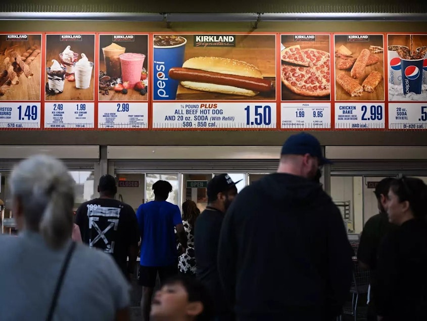 caption: Customers wait in line at a Costco food court in Hawthorne, California.
