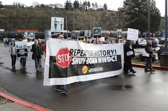 caption: About 40 Japanese Americans gathered at the King County International Airport on Tuesday, Feb. 21, 2024 and called for an end to deportation flights.