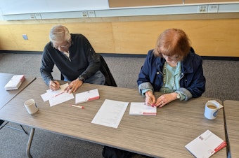 caption: On Sept. 17, 2024, AARP members gathered at the Mercer Island Community Center to sign postcards urging others to vote down Initiative 2124.