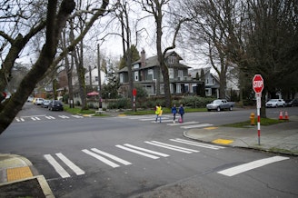 caption: Betty Gray, 80, also known as "Miss Betty," helps students across the street after school on Tuesday, Jan. 14, 2025, outside of Stevens Elementary School in Seattle. 