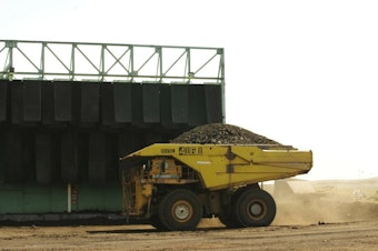 caption: A giant truck hauls coal at a mine in the Powder River Basin in Wyoming