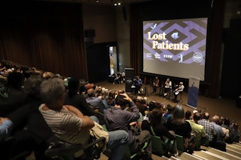 caption: A crowd turned out for the live conversation following the "Lost Patients" podcast series at the Seattle's Central Library on May 9, 2024. 