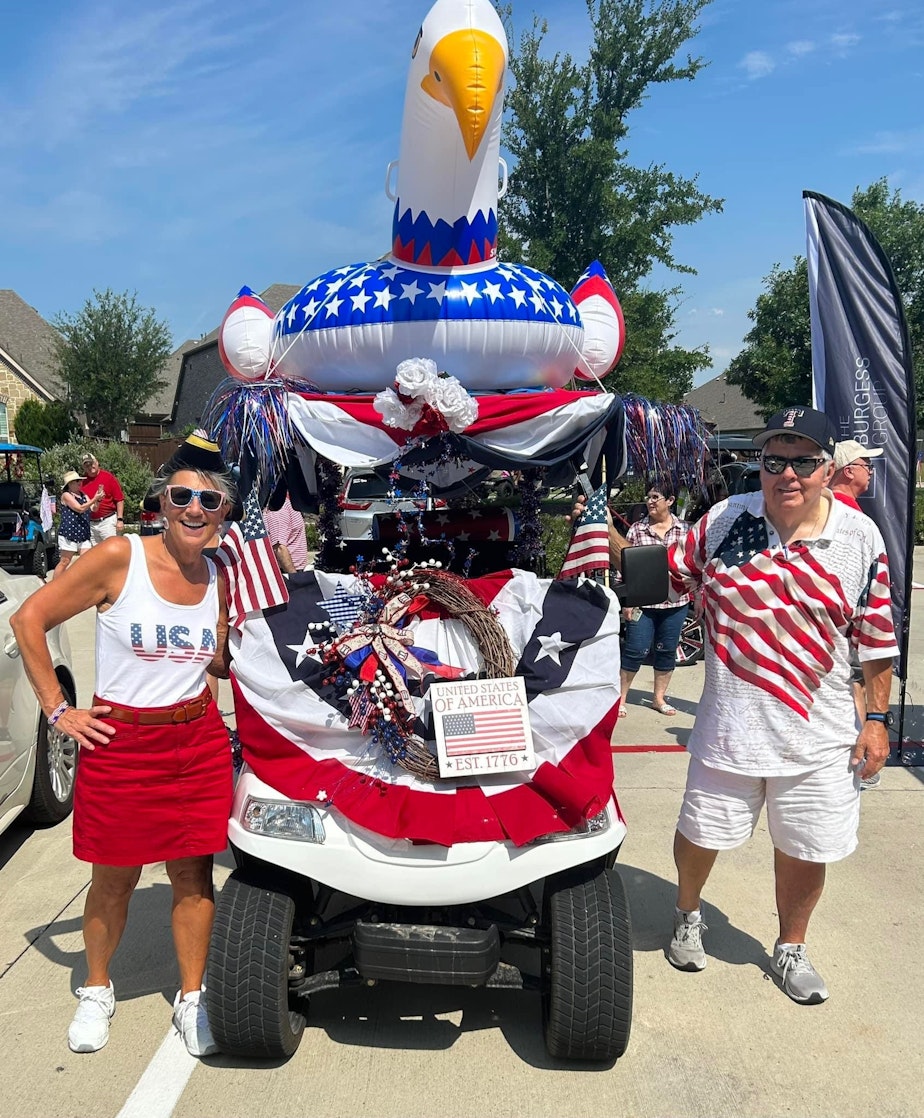 caption: Kirby Wilbur, right, and his wife Trina at their neighborhood's 4th of July golf cart parade last year.