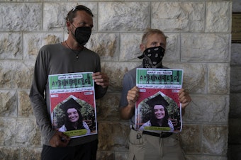 caption: Two fellow activists of Aysenur Ezgi Eygi, 26, who a witness says was fatally shot by Israeli soldiers while participating in an anti-settlement protest in the West Bank, carry posters with her name and photo during Eygi's funeral procession in the West Bank city of Nablus, Monday, Sept. 9, 2024. 