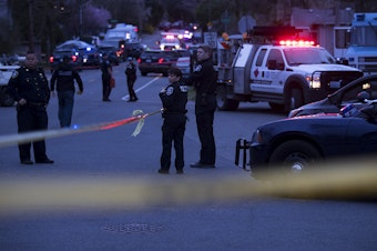 caption: Police investigate the scene of a fatal carjacking and shooting on Wednesday, March 27, 2019, at the intersection of 120th Street and Sandpoint Way Northeast in Seattle.