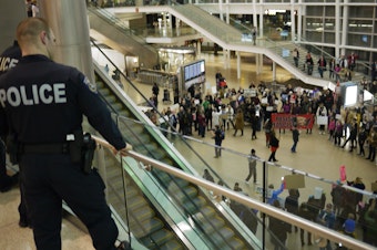 caption: Protests against travel ban erupt at SeaTac Airport in January.