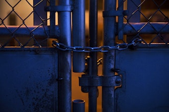 caption: A locked gate is shown at an outdoor play court at View Ridge Elementary School in northeast Seattle on Thursday, November 19, 2020. A Seattle Schools investigation revealed that a second-grade boy had been placed in this enclosure, dubbed “the cage” by school staff members, on multiple occasions during the school day.