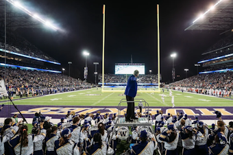 caption: Dr. Brad McDavid, director of the Husky Marching Band, during a performance at Husky Stadium. 