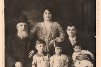 caption: Becky Benaroya (née Benoun) as a child (front center) with her grandfather Yosef, mother Dona, father Judah, brother Sam, and sister Nellie.