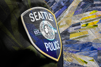 caption: A collage of a Seattle Police patch on an officer's uniform against a newspaper texture background. Original photo courtesy of the Seattle Police Department.