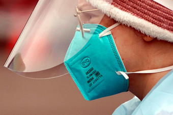 caption: Linsey Jones, a medical assistant working at a drive-up Covid-19 testing clinic, wears an N95 mask, Jan. 4, 2022, in Puyallup, Wash., south of Seattle.