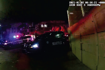 caption: Still image from the bodycam footage of a Seattle Police officer on Jan. 1, 2021, that shows the concrete barrier, some of the protesters' statements, and the police response.