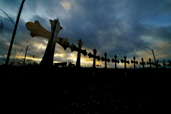 caption: A truck passes crosses placed along the highway to honor the victims killed in the recent school shooting at Robb Elementary School, Friday, June 3, 2022, in Uvalde, Texas. Two teachers and 19 students were killed. 