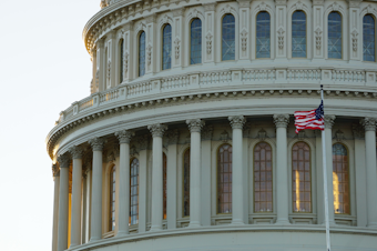 caption: A flag flies in front of the U.S. Capitol in Washington, D.C.